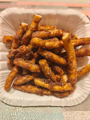 A plate of Karupatti Nattu Sakkarai Sevu, which are crisp, golden-brown colored snack sticks.